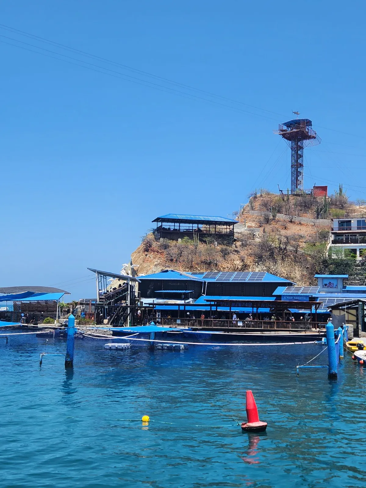 Acuario de El Rodadero con techos azules sobre el mar y torre mirador en el cerro.